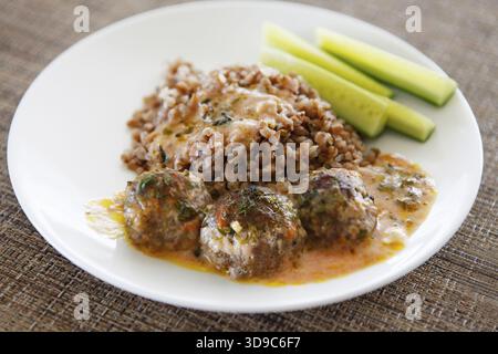 Le sarrasin avec de petites boules de viande rouge, et souse concombres frais Banque D'Images