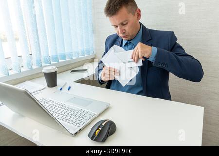 Homme d'affaires avec lettre, enveloppe - ouvert. homme d'affaires considérer recevoir la correspondance papier ou le message de document au lieu de travail. Banque D'Images