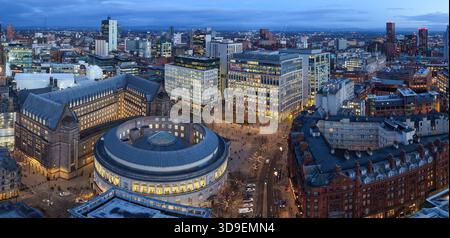 Vue aérienne au crépuscule de la skyline hivernale de Manchester, avec des lumières festives, la roue de Noël et des décorations saisonnières éclatantes. Banque D'Images