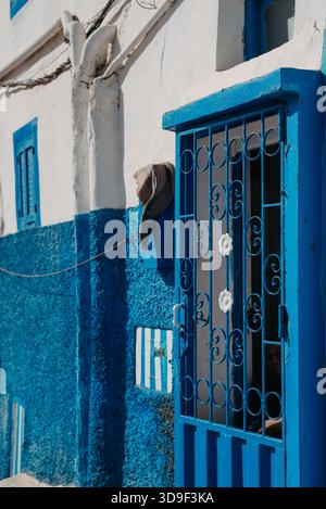 Porte bleue et façade texturée à Taghazout, Maroc Banque D'Images