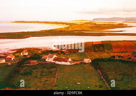 Vue sur les bâtiments de ferme en chaume à Magheraroarty Beach, Meenlaragh, comté de Donegal, Irlande des années 1960 Banque D'Images