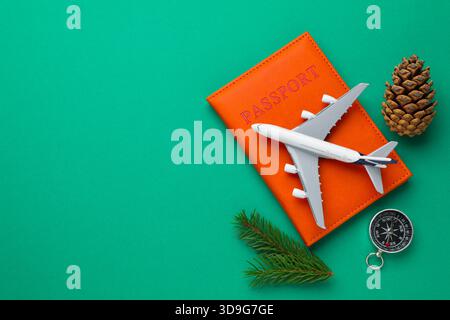 Vacances de Noël. Passeport, avion jouet, boussole et décor sur fond turquoise, pose plate. Espace pour le texte Banque D'Images