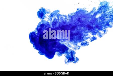 Encre bleue injectée dans l'eau à partir de la seringue, mélange de couleurs avec de l'eau créant des formes abstraites Banque D'Images