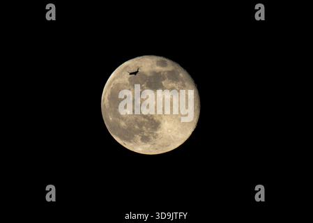 Lisbonne, Portugal. 05th Dec, 2025. Un avion vole près de la silhouette de la lune, qui s'élève au-dessus du ciel de Lisbonne. Mère nature a décidé d'afficher la dernière super lune de l'année, connue sous le nom de super lune froide. À sa phase complète et coïncidant avec son périgée, le satellite était situé à seulement 356 000 kilomètres de la Terre, apparaissant jusqu'à 14% plus grand et 30% plus lumineux qu'une pleine lune conventionnelle. (Photo de Jorge Castellanos/SOPA images/SIPA USA) crédit : SIPA USA/Alamy Live News Banque D'Images