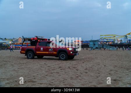 Santa Monica, CALIFORNIE, États-Unis. 26 septembre 2025. - Un sauveteur rouge du comté de Los Angeles et camionnette du service des incendies est garé sur le sable Santa Monica b Banque D'Images