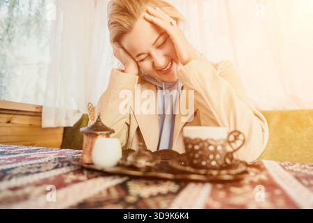 Femme, thé, café - femme souriante aime une tasse de thé dans un café. Banque D'Images