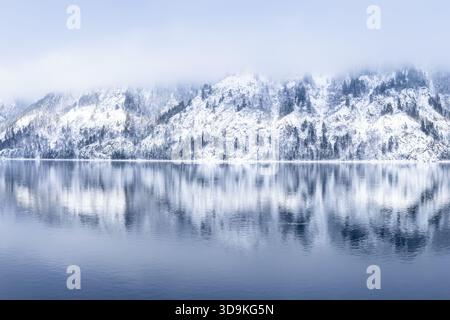 Montagnes enneigées avec des pins, reflet dans la rivière Yenisei, beau fond d'hiver. Un paysage hivernal serein mettant en vedette Majestic Banque D'Images