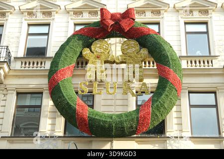 Décoration de couronne de Noël festive géante suspendue sur une façade de bâtiment. 22 novembre 2025, Vienne, Autriche. Banque D'Images
