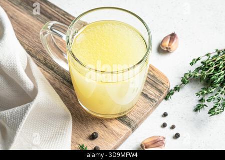 Bouillon de guérison chaud (bouillon d'os de poulet) avec herbes et épices. Bouillon de collagène buvable de poulet, alimentation saine. Banque D'Images