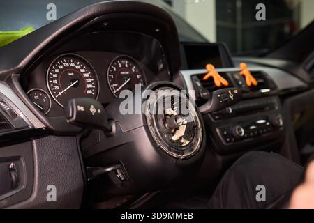 Réparation détaillée de la voiture, prise de vue ciblée des mains restaurant soigneusement le composant de direction du véhicule, travail de précision sur le volant du véhicule avec des outils dans Banque D'Images