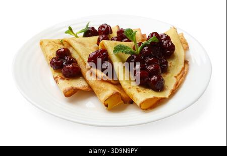 Crêpes savoureuses aux cerises et à la menthe isolées sur blanc Banque D'Images