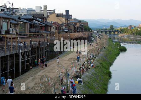 Les terrasses de restauration « kawayuka » (川床) situées en bordure de rivière offrent une brise fraîche naturelle dans les chaudes soirées estivales le long de la rivière Kamo à Kyoto, au Japon. Banque D'Images
