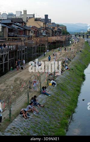 Les terrasses de restauration « kawayuka » (川床) situées en bordure de rivière offrent une brise fraîche naturelle dans les chaudes soirées estivales le long de la rivière Kamo à Kyoto, au Japon. Banque D'Images