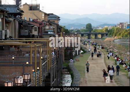Les terrasses de restauration « kawayuka » (川床) situées en bordure de rivière offrent une brise fraîche naturelle dans les chaudes soirées estivales le long de la rivière Kamo à Kyoto, au Japon. Banque D'Images
