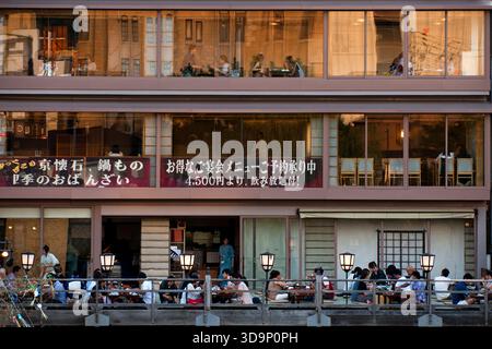 Les terrasses de restauration « kawayuka » (川床) situées en bordure de rivière offrent une brise fraîche naturelle dans les chaudes soirées estivales le long de la rivière Kamo à Kyoto, au Japon. Banque D'Images