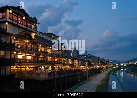 Les terrasses de restauration « kawayuka » (川床) situées en bordure de rivière offrent une brise fraîche naturelle dans les chaudes soirées estivales le long de la rivière Kamo à Kyoto, au Japon. Banque D'Images