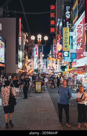 Le quartier emblématique de Dotonbori à Osaka s'anime la nuit, avec des panneaux d'affichage imposants illuminant la rue en contrebas. Banque D'Images