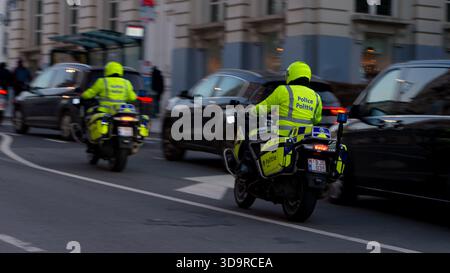 BRUXELLES, BELGIQUE - 26 NOVEMBRE 2025 - des policiers en train réfléchissant conduisent des motocyclettes dans la circulation urbaine très fréquentée à Bruxelles Banque D'Images