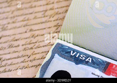 Vue rapprochée d'un visa américain estampillé sur une page de passeport avec fond de Constitution américaine. Concept de voyage et d'immigration Banque D'Images