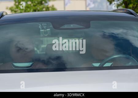 Un intérieur de voiture avec caméra avant montée sur le tableau de bord comme dashcam fixé au pare-brise sièges en cuir marron volant visible photographié comme automoteur Banque D'Images