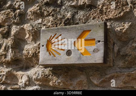 Un marqueur guide les pèlerins le long du Camino del Norte à leur entrée dans Santillana del Mar, Cantabrie, Espagne. La coquille Saint-Jacques et la flèche jaune sont ubiquit Banque D'Images