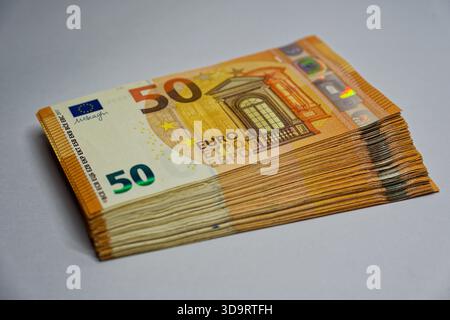 Une pile épaisse de cinquante billets en euros se trouve au carré dans une pile haute, les coins nets captent la lumière et les bords propres du papier montrent de l'argent frais prêt pour c Banque D'Images