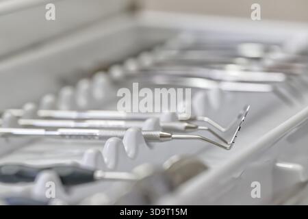Une vue rapprochée des instruments dentaires disposés soigneusement sur un plateau, présentant divers outils utilisés dans les procédures dentaires. Banque D'Images