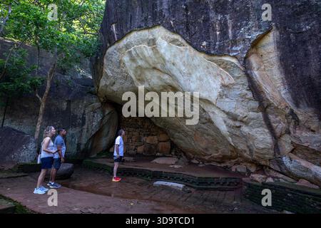 SIGIRIYA, Sri LANKA - 02 DÉCEMBRE 2025 : les visiteurs de Sigiriya Rock voient des fresques anciennes à la grotte Deraniyagala à Sigiriya dans le centre du Sri Lanka. Banque D'Images