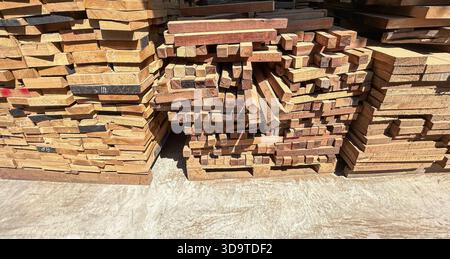 Les planches de bois s'empilent dans la scierie. Empilé de bois sur le sol dans l'usine de meubles Banque D'Images