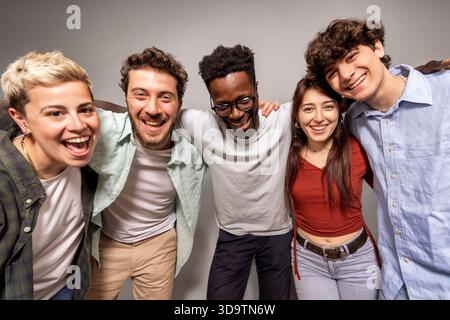 Groupe de jeunes multiculturels posant joyeusement en studio, montrant la joie, la connexion et des relations humaines authentiques Banque D'Images