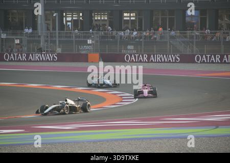 Les voitures participent au Grand Prix du Qatar 2025 sous les yeux des spectateurs depuis les tribunes de la piste de course pendant l'événement. Banque D'Images