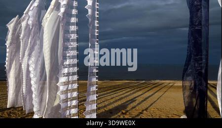Affichage d'art textile abstrait avec drapeaux en dentelle blanche sur Cervia Beach au crépuscule Banque D'Images