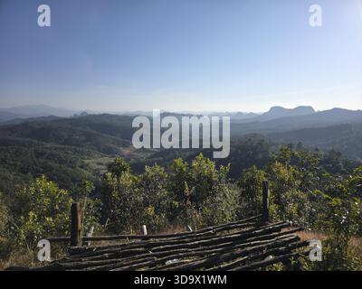 Le vaste paysage révèle un paysage de montagne tranquille, avec une forêt verdoyante couvrant des collines ondulantes et des sommets lointains, offrant une vue imprenable sur l'extérieur Banque D'Images