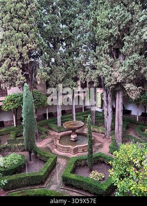 Jardin de la cour avec fontaine centrale à l'Alhambra à Grenade, en Espagne, arcs mauresques et design géométrique islamique. Banque D'Images