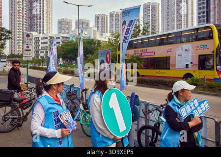 Hong Kong, Chine. 07 décembre 2025. Assistants de candidats vus devant un bureau de vote à Tin Shui Wai. Les élections générales du Conseil législatif de Hong Kong de 2025 ont lieu le 7 décembre 2025 pour élire les 90 membres du 8ème Conseil législatif de Hong Kong. Crédit : SOPA images Limited/Alamy Live News Banque D'Images