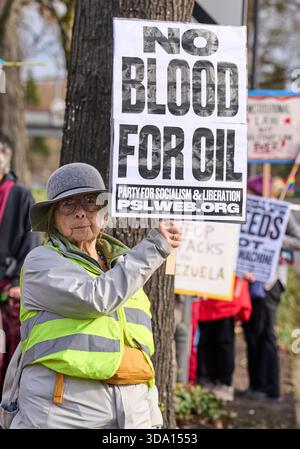 Une femme tient une pancarte alors que des manifestants à Eugene, Oregon, dénoncent une guerre américaine contre le Venezuela le 6 décembre 2025. Banque D'Images