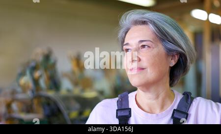 Ouvrière d'usine féminine mature regardant confiant et plein d'espoir Banque D'Images