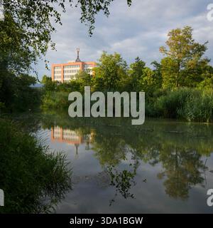 Vienne, Autriche - 2 août 2024 : le Marchfeldkanal avec un ancien immeuble de bureaux en arrière-plan capturé à la lumière du jour d'été Banque D'Images
