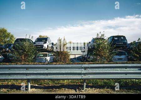 VO, italie 28 octobre 2025 : casier de voitures et d'épaves rouillées empilées en hauteur pour le recyclage des métaux et l'élimination des véhicules, garde-corps au premier plan Banque D'Images