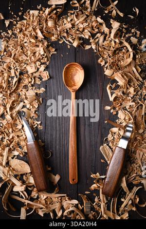 Cuillère en bois fabriquée à la main avec tas de limailles en bois avec des outils de menuiserie manuelle. Concept de fabrication artisanale Banque D'Images