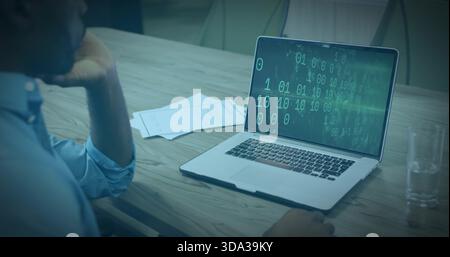 Homme penché en chemise bleue étudiant le code vert de l'ordinateur portable à la conférence papiers de table, verre, espace de copie Banque D'Images