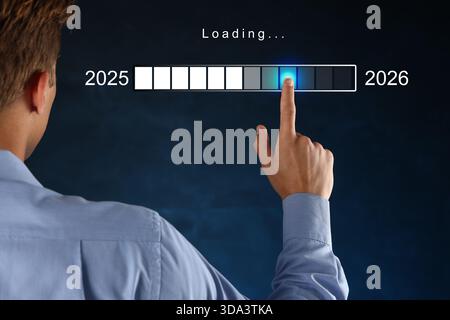 Homme d'affaires utilisant l'écran virtuel avec la barre de chargement sur fond bleu foncé, gros plan. Nouvel an 2026 Banque D'Images