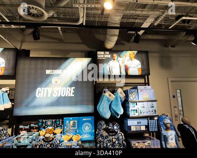 Manchester, Royaume-Uni - 16 novembre 2025 : magasin lumineux avec équipement Manchester City, vêtements bleus et étagères de présentation. Banque D'Images
