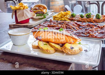 Filets de saumon norvégien grillés avec une sauce aux fruits de la passion et au gingembre, servis sur un lit d'épinards sautés. Banque D'Images