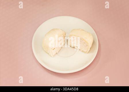 Mochi tricolore (blanc, rose et vert) rempli d'anko lisse, représentant les couleurs du drapeau japonais, présenté sur une plaque de céramique avec flore Banque D'Images