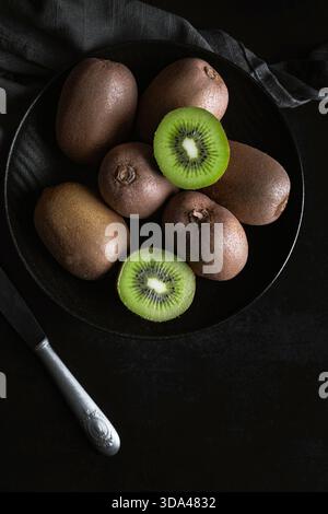 Gros plan de kiwis verts frais sur un fond sombre Banque D'Images