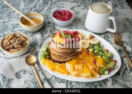 Délicieuse pile de crêpes sans gluten servies avec une salade de fruits frais. Banque D'Images