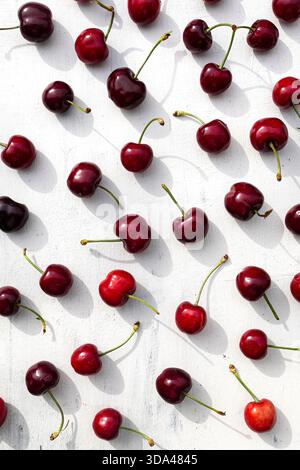 Gros plan de cerises rouges fraîches sur un fond blanc propre Banque D'Images