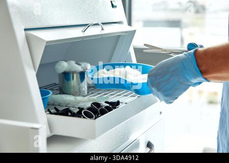 Dans un espace de travail bien organisé, un professionnel médical qualifié en gants prépare méticuleusement les échantillons de laboratoire pour garantir des résultats précis en analyse et en diamètre Banque D'Images