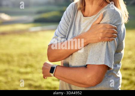 Fitness, sports, exercice et concepts de vie saine - femme mature avec blessure à l'épaule ou au bras à l'extérieur. Blessure au bras chez une athlète âgée joggi Banque D'Images